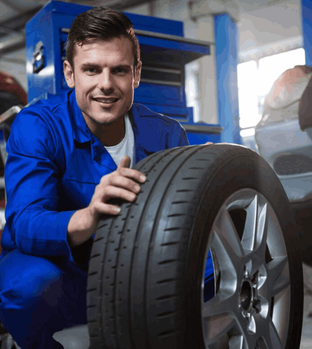Mechanic examining tyre Mechanic examining tyre<br />